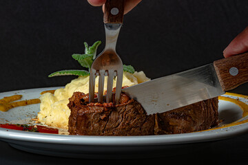 Filet mignon with fried onion and mashed potato, decorated with cherry tomatoes and mustard sauce...