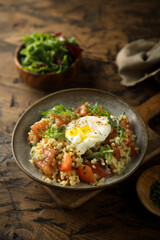 Healthy warm bulgur salad with poached egg