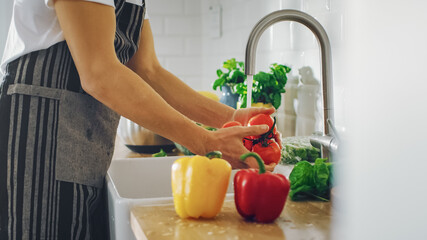 Close Up Shot of a Person Washing Red Sweet Pepper with Tap Water. Authentic Stylish Kitchen with Healthy Vegetables. Natural Clean Products from Organic Farming and Green Diet Concept.