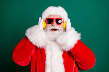 Close-up portrait of his he nice handsome cheerful cheery Santa father listening different pop music soul jazz having fun enjoying free spare time isolated over green color background