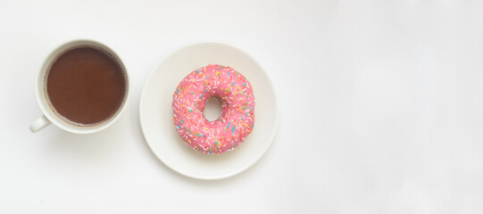 A cup of cacao drink and pink donut on white background, space for text