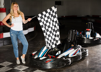 Portrait of young girl holding finish flag at kart racing track