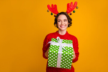 Photo of beautiful lady hold winter holiday big giftbox festive event party x-mas surprise look side glad wear deer horns decor red knitted sweater isolated yellow color background