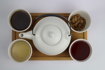 Fototapeta na wymiar japanische Teekanne mit kleinen weißen Teetassen und unterschiedlichen Teesorten 