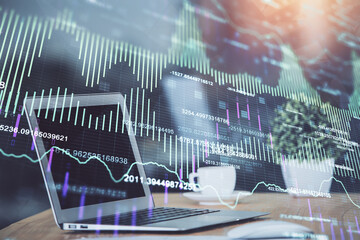 Forex market graph hologram and personal computer on background. Multi exposure. Concept of investment.