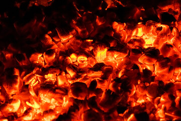 Hot and burning coals in a brazier at night.