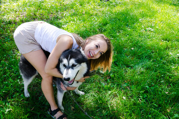 Naklejka na ściany i meble attractive blonde hugs her dog in the park.