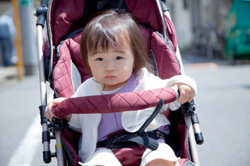 ベビーカーに乗って散歩する女の子