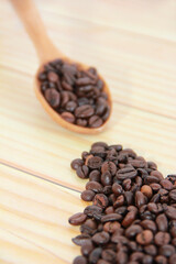 natural black coffee beans in a wooden spoon