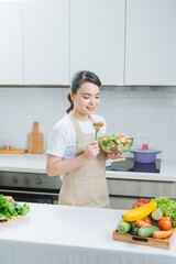 Young woman eating salad and holding a mixed