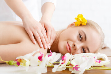 Relaxing in spa. Smiling girl lies on massage table