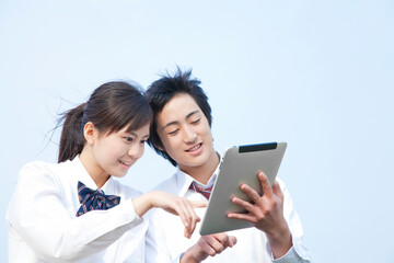 タブレットPCを見る高校生カップル © Paylessimages