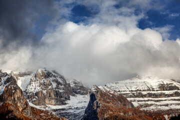 Naklejka na ściany i meble Beautiful landscape. Dolomites in Italy. Fluffy clouds over mountain tops