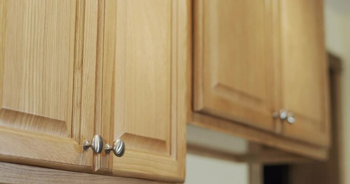 Rack focus shot of newly remodeled kitchen cabinets finished in light wood.