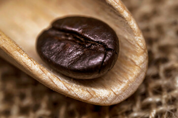 Coffee beans. Macro photo Burlap fabric. Wooden spoon for coffee. Rough fabric texture. Fabric Canvas. Coffee beans on sacking. Coffee abstraction.