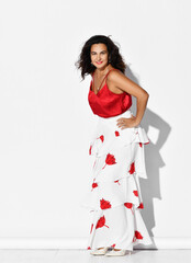Gorgeous woman hispanic dancer wearing red white gown with flower print dances Carmen flamenco holding hands on hips