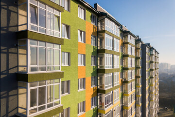 Fototapeta premium Aerial view of a tall residential apartment building with many windows and balconies.