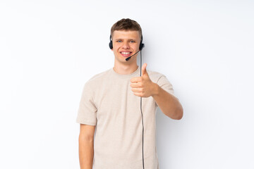 Young handsome man over isolated white background working with headset with thumb up