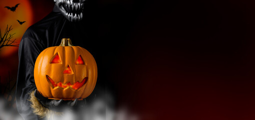 Werewolf or zombie holding pumpkin ghost on Halloween. Black backgournd with copy space for text.