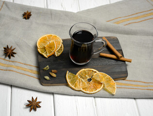 Glass glass of mulled wine on a gray napkin, with orange slices and anise stars. Top view