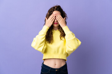 Young caucasian woman isolated on purple background covering eyes by hands