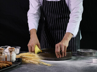Hands cleaning the bread pan before preparing bread dough in the kitchen, food homemade bakery concept