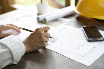 Architect's desk, Architects are analyzing the house structure, Focus on the hand, Close up.