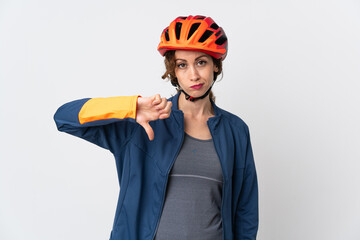 Young cyclist woman isolated on white background showing thumb down with negative expression