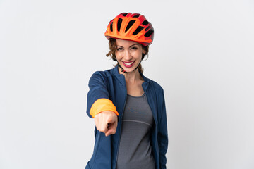 Young cyclist woman isolated on white background pointing front with happy expression