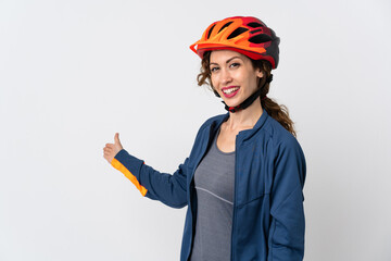Young cyclist woman isolated on white background extending hands to the side for inviting to come