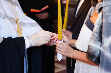 The priest puts rings on the bride and groom during the wedding ceremony