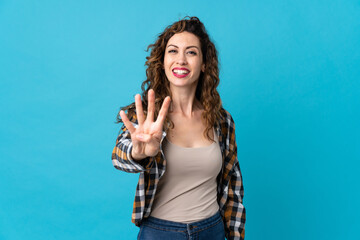 Young caucasian woman isolated on blue background happy and counting four with fingers