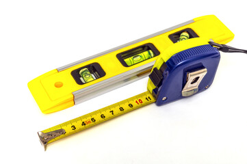 Building level and tape measure for leveling or measuring objects on white background