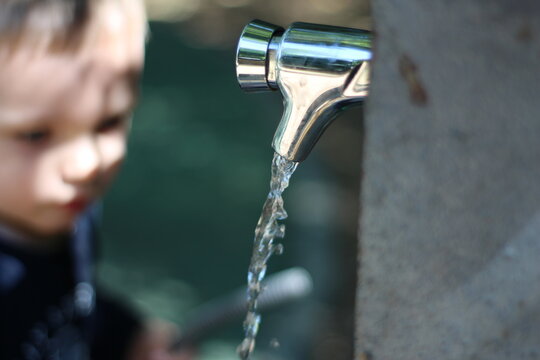 robinet d'eau avec enfant qu i iboit