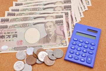 日本の一万円札と硬貨と電卓