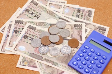 日本の一万円札と硬貨と電卓