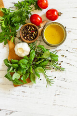 Ingredients for cooking. Herbs spices, olive oil and vegetables on a wooden table. Top view flat lay background. Copy space.