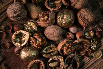 Still life with Walnut kernels and whole walnuts on rustic old wooden table. Creative table decoration.