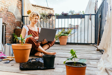Work from home or study online, concept with a woman gardener working at laptop outdoor on terrace,...