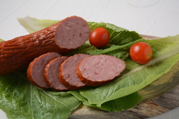Sliced spicy smoked beef/ pork sausage.With lettuce leaf and cherry tomatoes.
