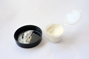 Jar with face and body cream on a light background.