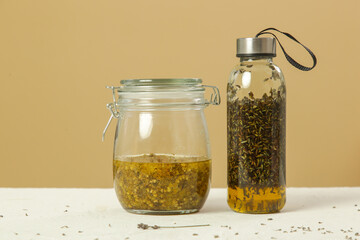 Herbal infused oils with yellow immortelle and lavandula flowers. Process of maceration.	