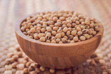 Closeup of fresh dry soybean seed in wooden bowl  on Water hyacinth placemats.