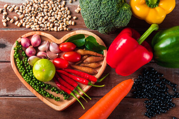 World food day, Top view of various fresh organic fruit and vegetable in heart plate with copy space, studio shot on wooden table, Healthy vegetarian food concept