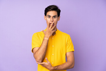 Man over isolated purple background surprised and shocked while looking right