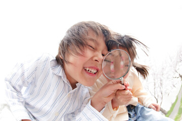 虫めがねで覗く子供