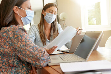 Business women working in office with face mask