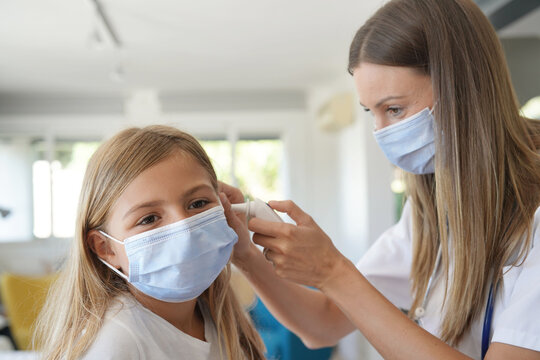 Kid At Doctor's Office With Protection Face Mask Having Temperature Checked