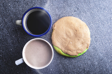 The cup of hot coffee with a cookie