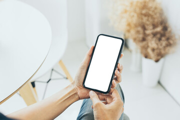 cell phone mockup blank white screen.woman hand holding texting using mobile on desk at coffee shop.background empty space for advertise.work people contact marketing business,technology